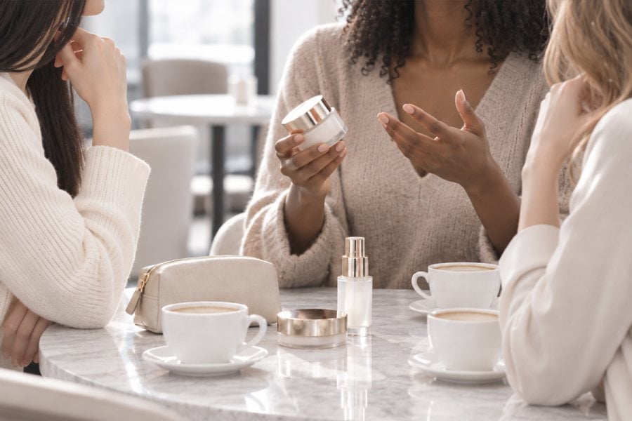 People discussing a beauty product at a café